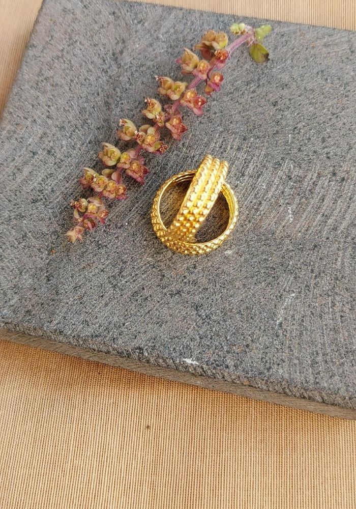 Traditional Three Layer Toe Ring on grey stone surface with scattered colorful flowers