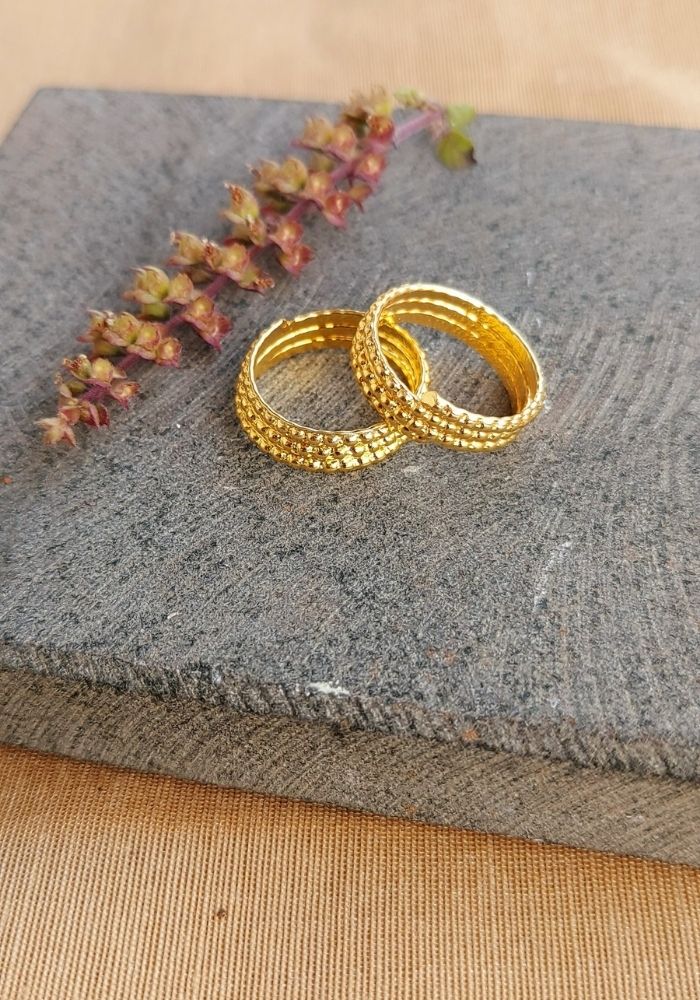 Traditional Three Layer Gold Toe Rings on Slate Background with Dried Flowers