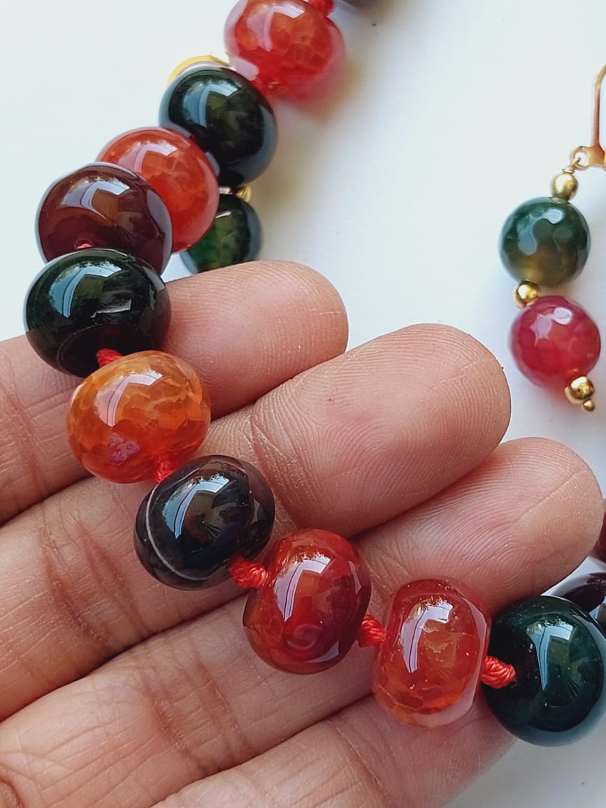 Red wine Dark Green Glass Beads Minimalistic Set - Vibrant glass beads in deep red and dark green hues, arranged in a simple, elegant design and held in a human hand.