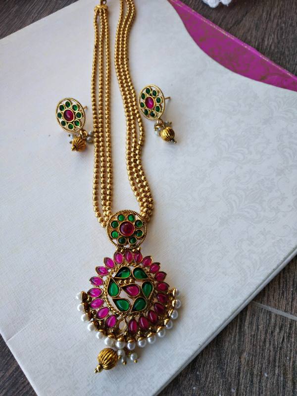 Multicolour Karwari Pendant Set - Elegant gold-toned necklace with a vibrant floral pendant and matching earrings, featuring colorful gemstones.