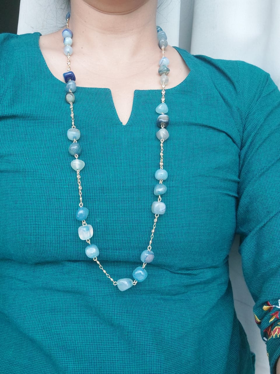 Elegant Blue Glass Beads and American Diamond Set Necklace - On a model wearing a teal green top, a stylish necklace made of blue glass beads and American diamond accents is prominently displayed.