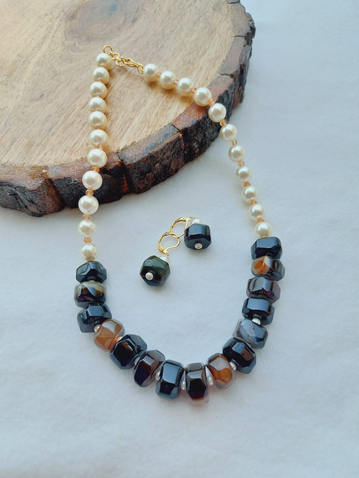 Premium Quality Natural Stone Pearl Necklace - Elegant pearl and stone beaded necklace with a gold-tone clasp, displayed on a rustic wood slice.