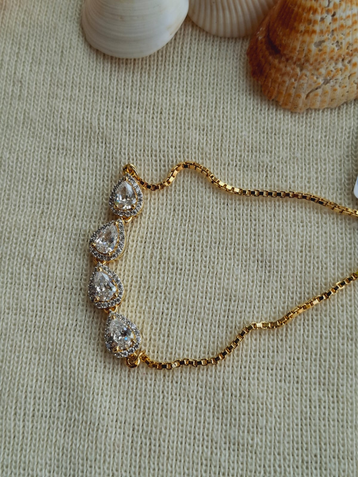 Elegant Golden Badam Bracelet with Sparkling Rhinestones on Cozy Knit Background