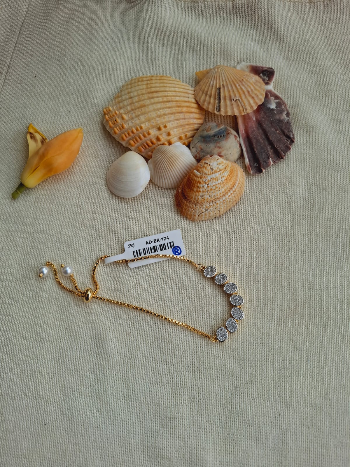 Beautiful Round Adjustable Bracelet from Mugdha Jewellery Store displayed on tan fabric with seashells
