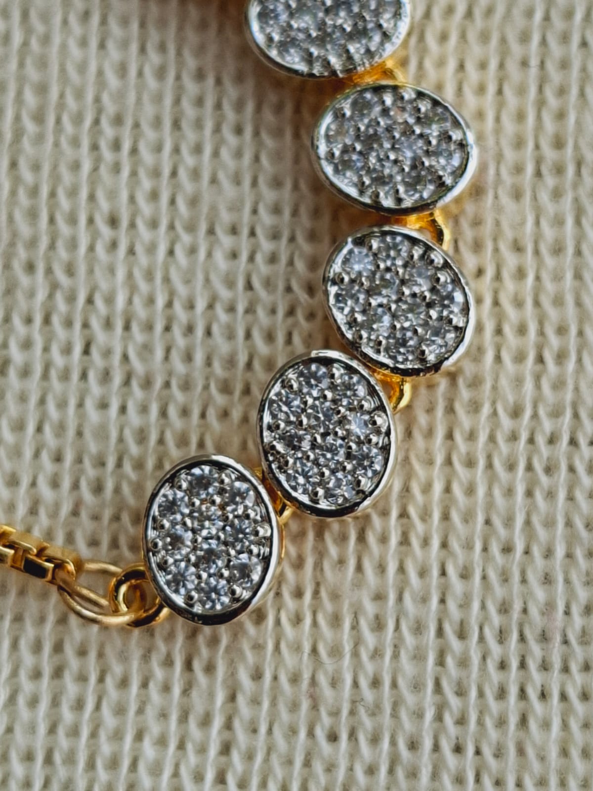 Sparkling Round Adjustable Bracelet
This image shows a beautiful adjustable bracelet with round, sparkling crystal accents set in a gold-tone frame, placed on a soft, textured surface.