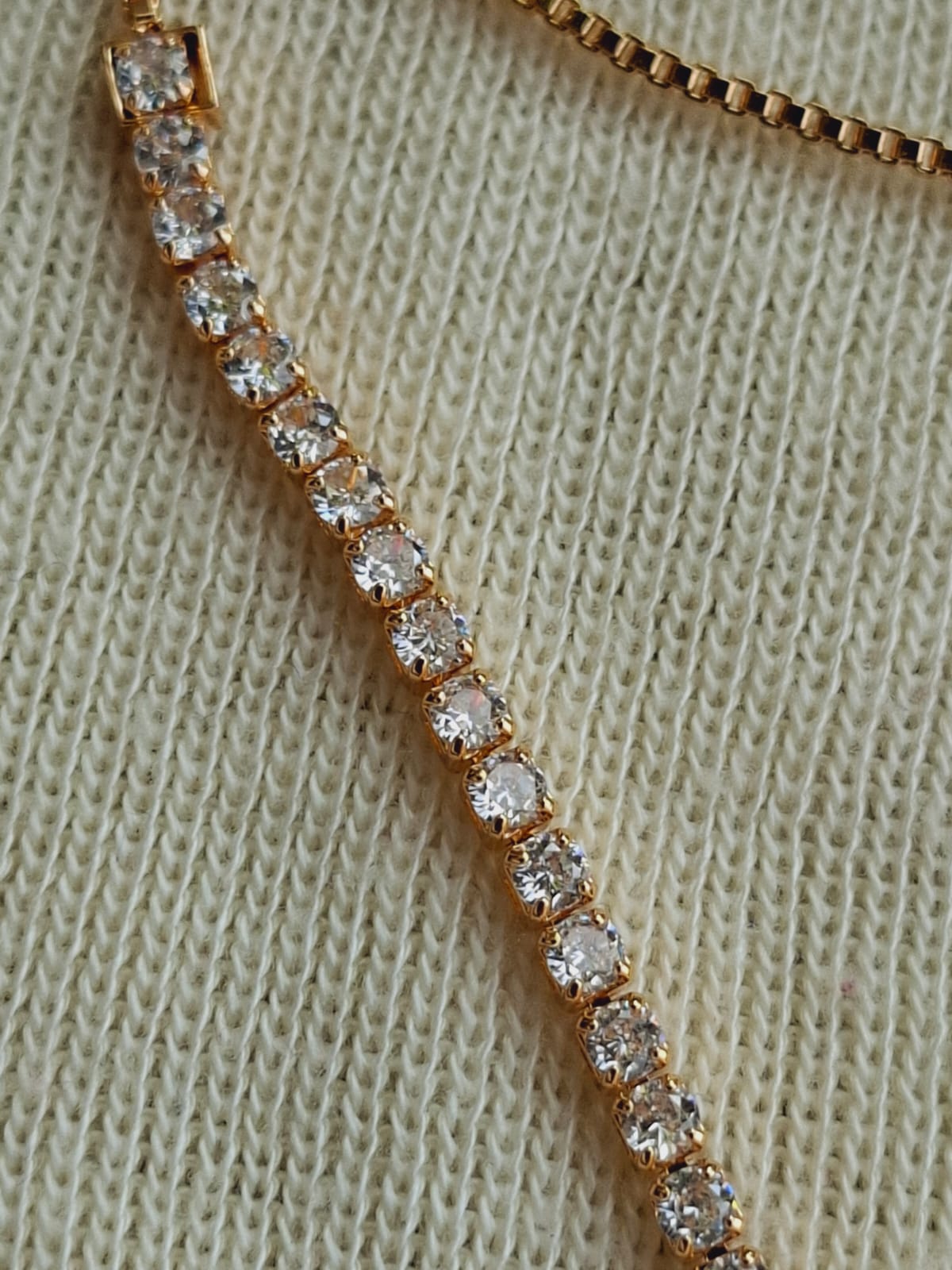 Elegant gold-toned adjustable bracelet adorned with sparkling American diamond stones, creating a stunning accessory piece.