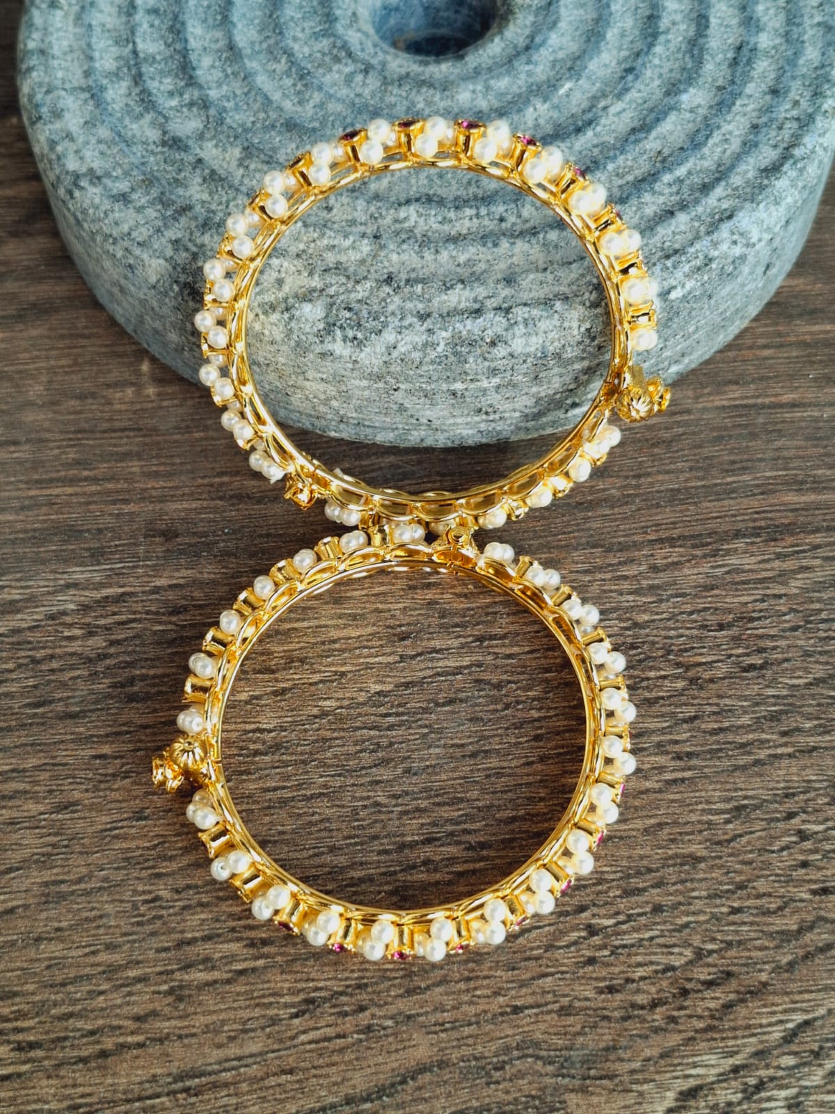 Elegant gold-toned jewelry with sparkling crystals, showcasing eye-catching design and premium craftsmanship on a natural stone backdrop