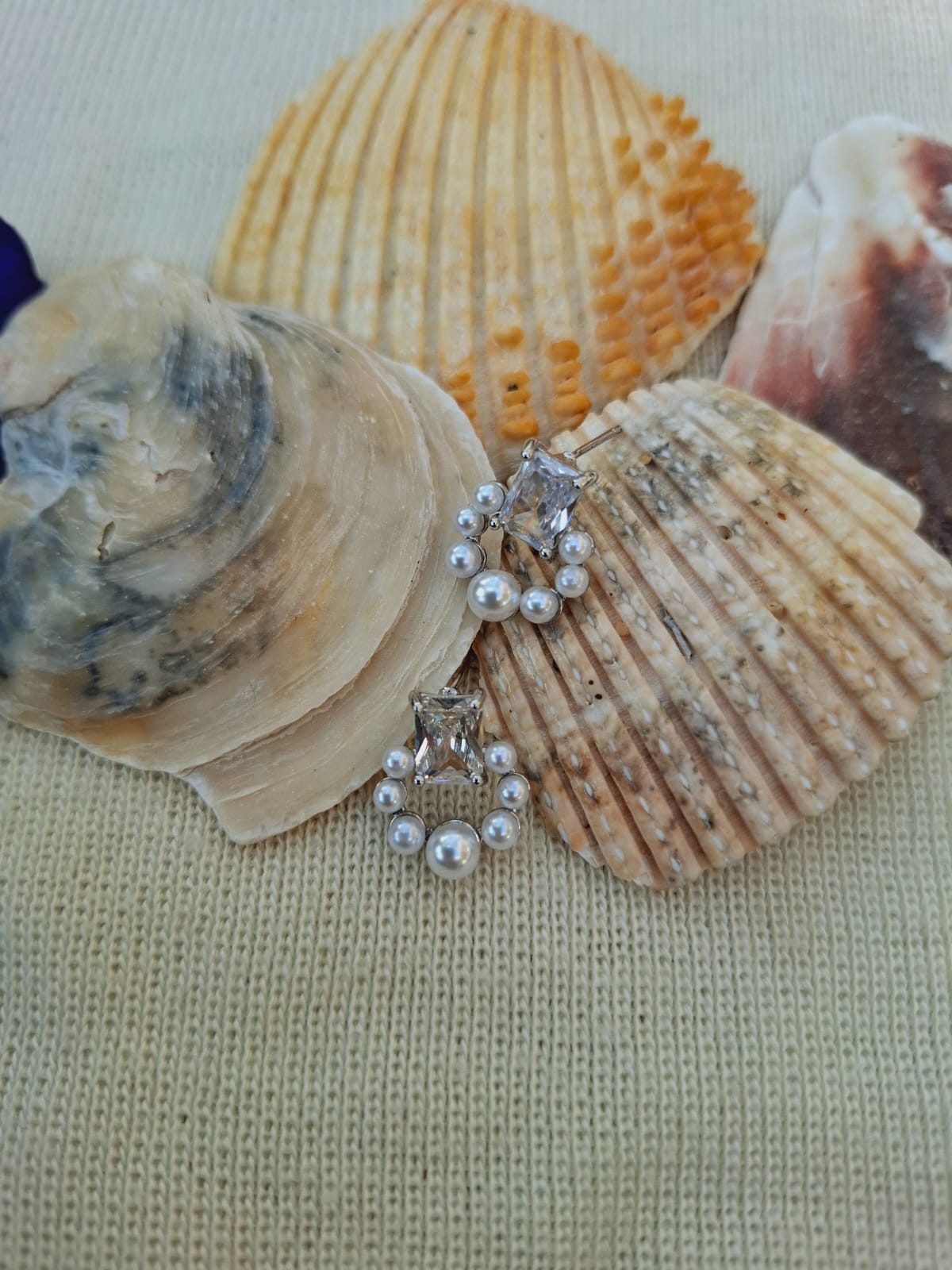 Elegant Pearl and Crystal Studs on Seashell Display