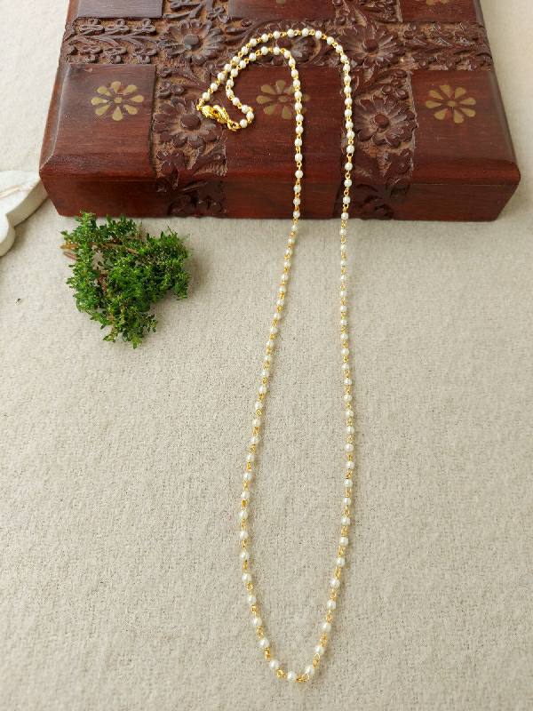 Elegant 1 Layer Rice Pearl Chain necklace on an antique wooden jewelry box with floral designs, surrounded by greenery.