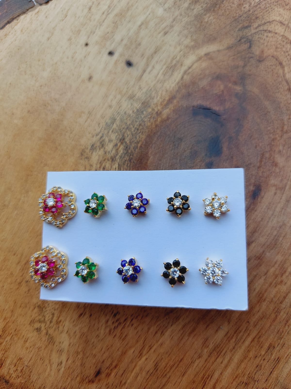5-in-1 Floral Changeable Earrings - Vibrant crystal flower earrings in assorted colors displayed on a white card against a wood background.