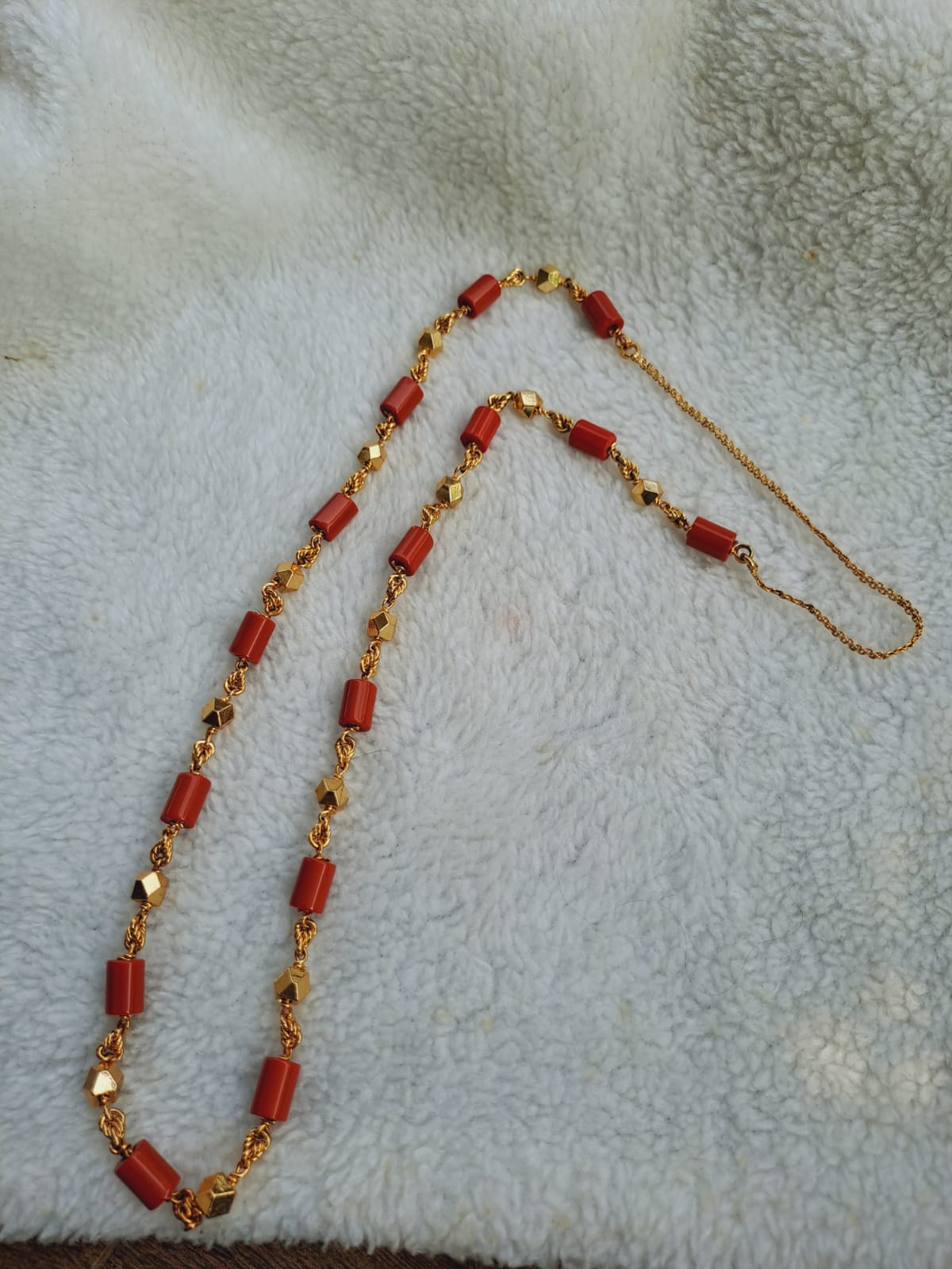 Elegant gold-toned chain with vibrant red rectangular beads, showcasing a sophisticated and eye-catching accessory from the Mugdha Jewellery Store.