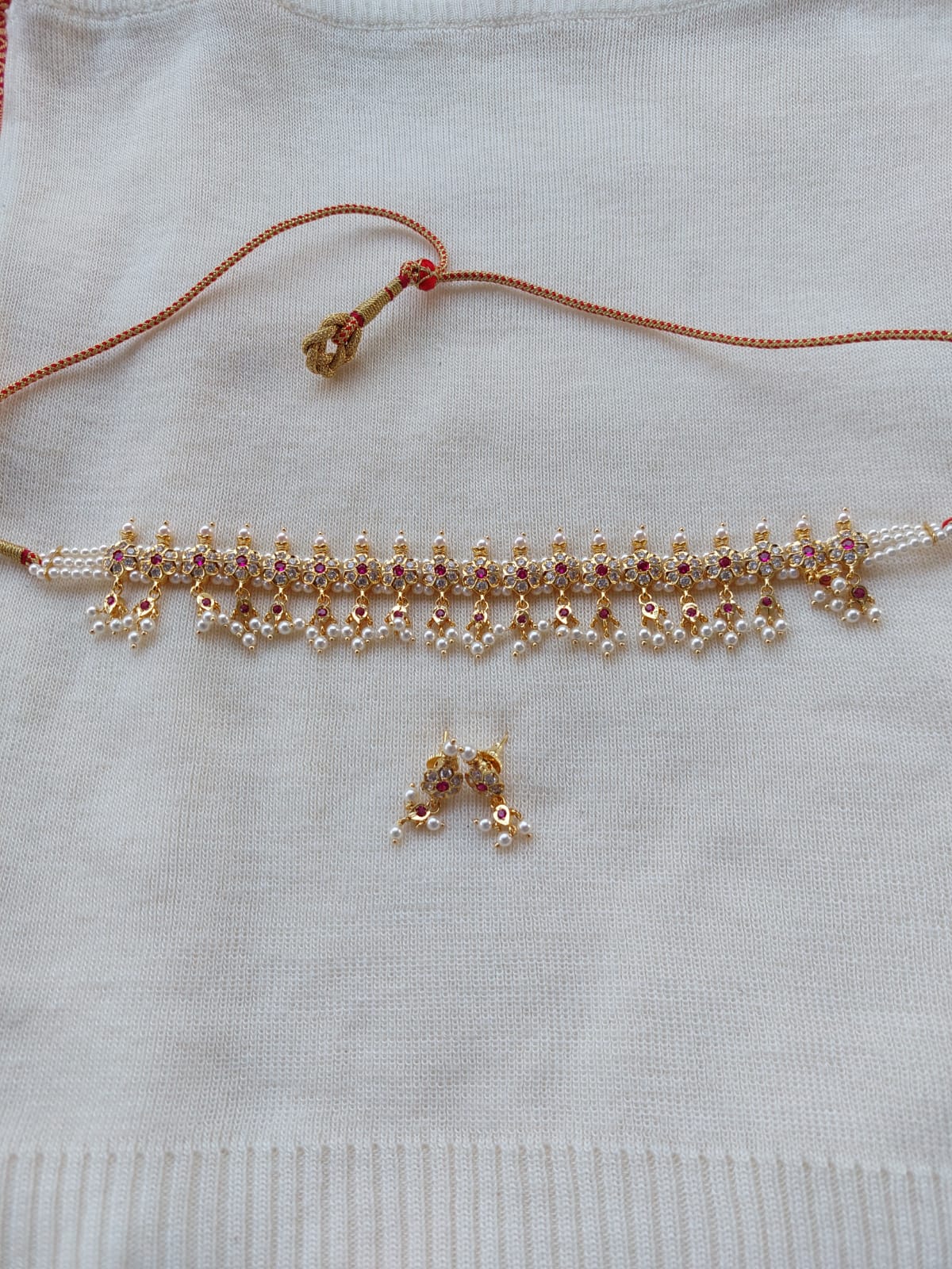 19 Patti Flower Chinchapeti - Elegant gold-toned Mugdha Jewellery Store necklace with intricate floral design and matching earrings against a white background.