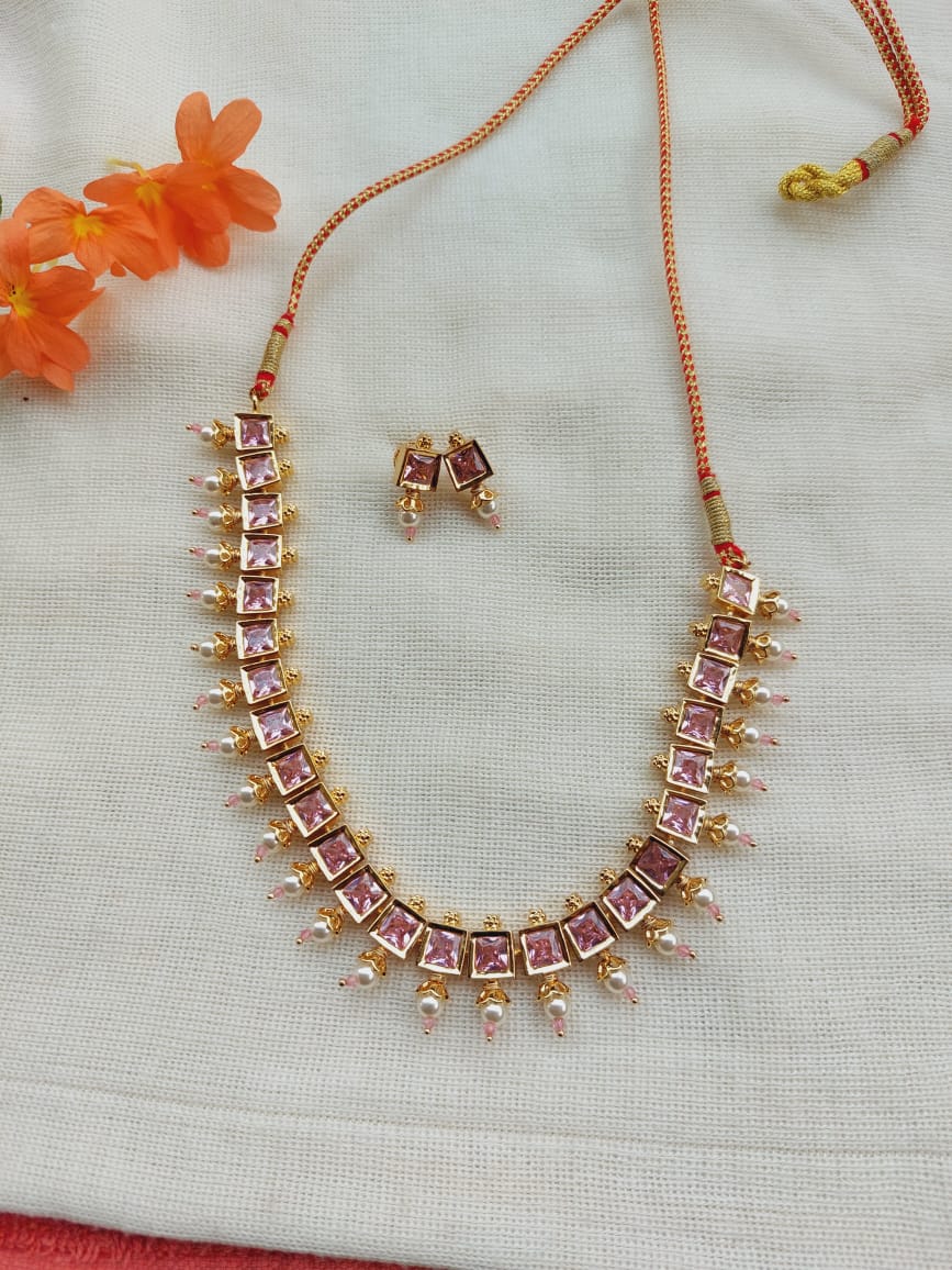 Elegant Light Pink Stone Necklace Set
This image shows a striking necklace and earring set from the Mugdha Jewellery Store. The necklace features a delicate chain with light pink stones arranged in a decorative pattern, creating a sophisticated and stylish look. The matching earrings complement the necklace, adding to the coordinated and polished aesthetic. The elegant design and vibrant color combination make this jewellery set a stand-out piece.