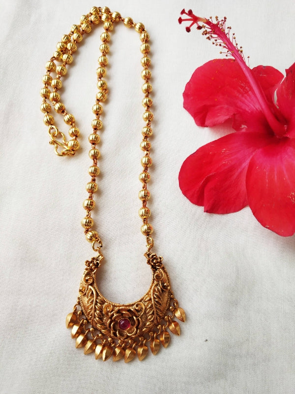 Ornate Temple Flower Designer Necklace from Mugdha Jewellery Store, featuring a bold red hibiscus blossom and intricately crafted gold-toned pendant on a beaded chain.