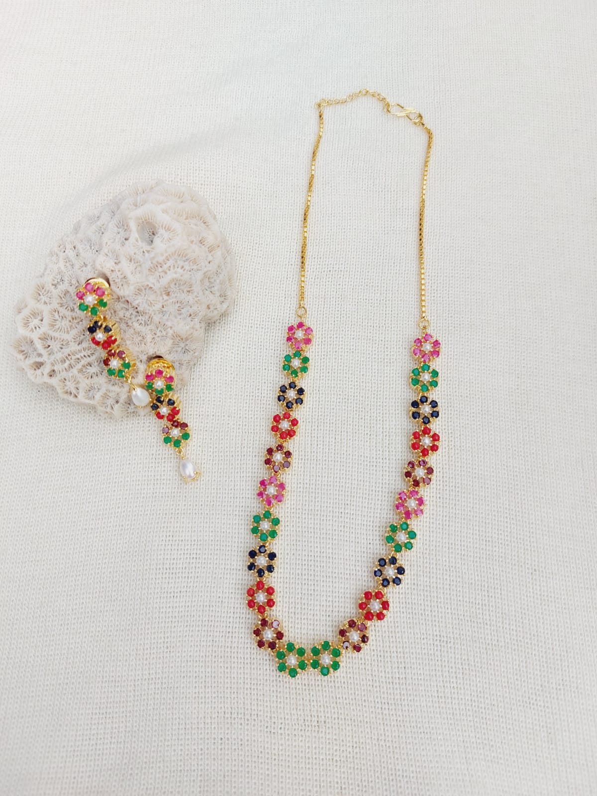 Colorful beaded flower necklace from Mugdha Jewellery Store featuring a vibrant array of red, pink, and green beaded flowers on a delicate gold-tone chain.