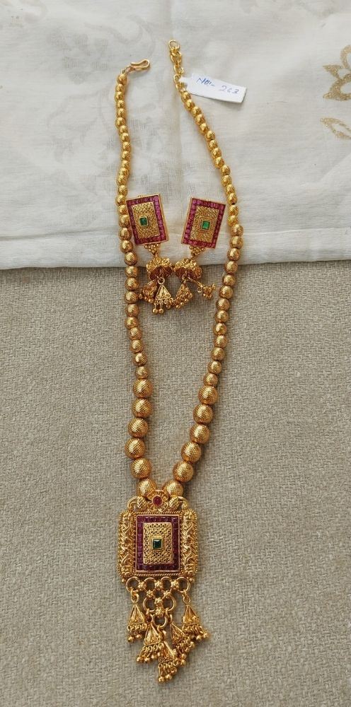 Square Pendant Short Designer Necklace from Mugdha Jewellery Store featuring ornate gold-toned beads, intricate red accents, and a central pendant design.