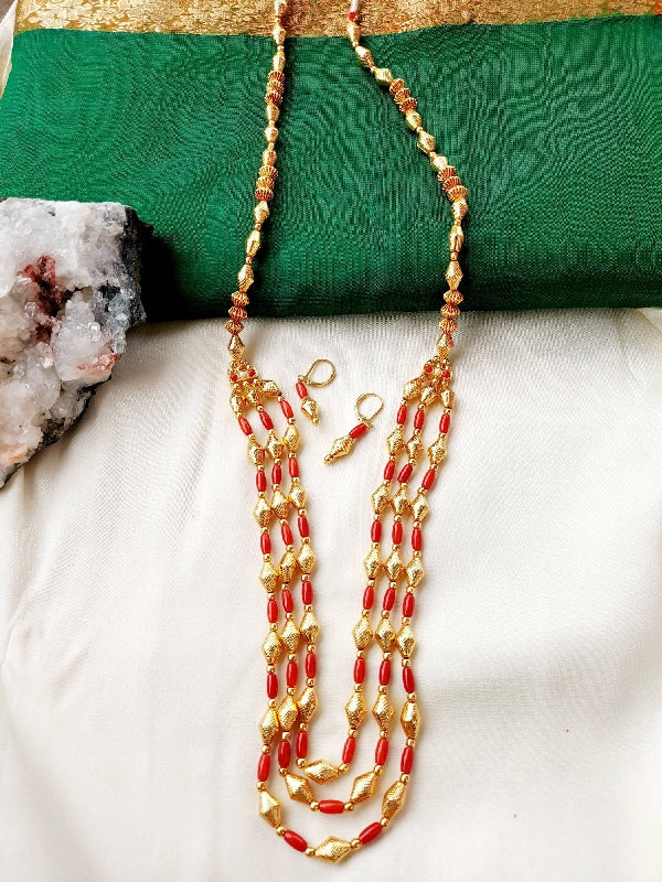 Elegant coral beaded necklace and earring set on green and gold background from Mugdha Jewellery Store