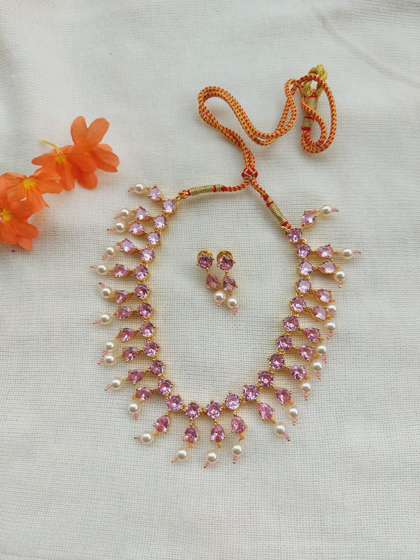Elegant light pink stone necklace and earrings set from Mugdha Jewellery Store displaying ornate floral design with sparkling crystals