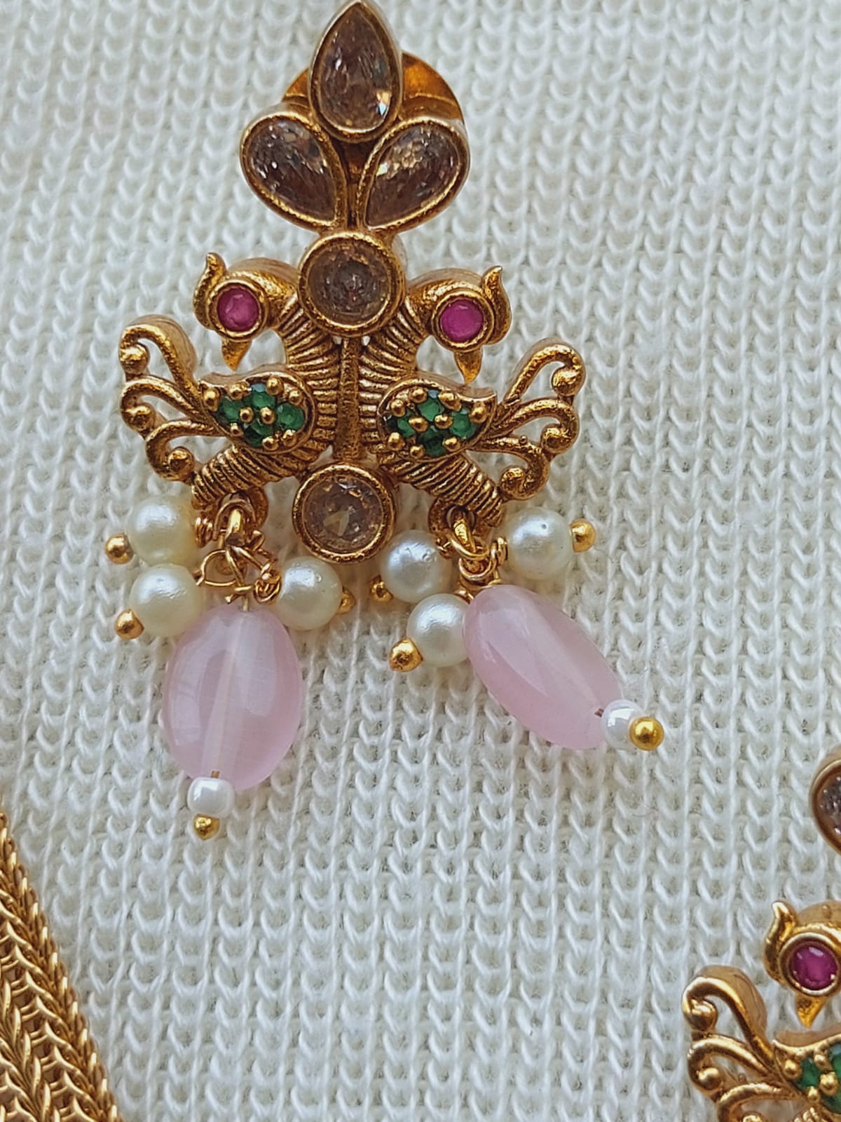 Designer Peacock Kundan Baby Pink Bead Set
A detailed jewelry set featuring a peacock-inspired design with kundan work, pink beads, and gold-toned accents.