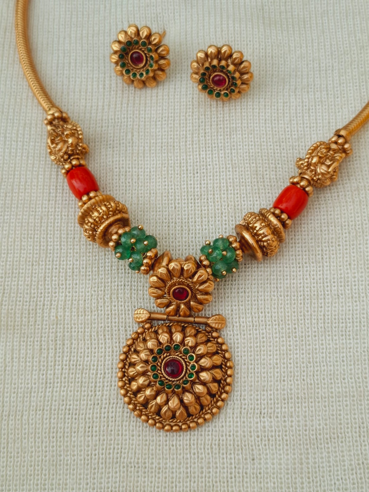 Elegant gold-toned necklace with intricate floral designs and colorful gemstones from Mugdha Jewellery Store.