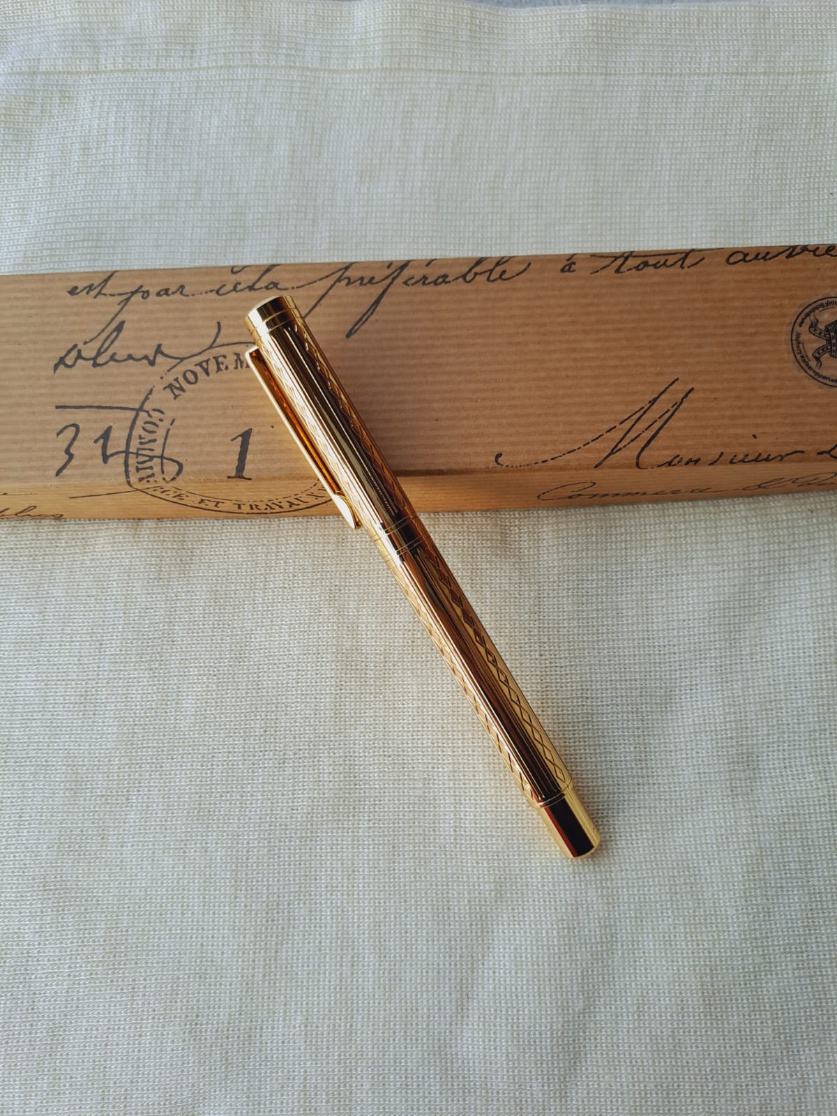 Elegant gold-toned designer pen atop vintage document