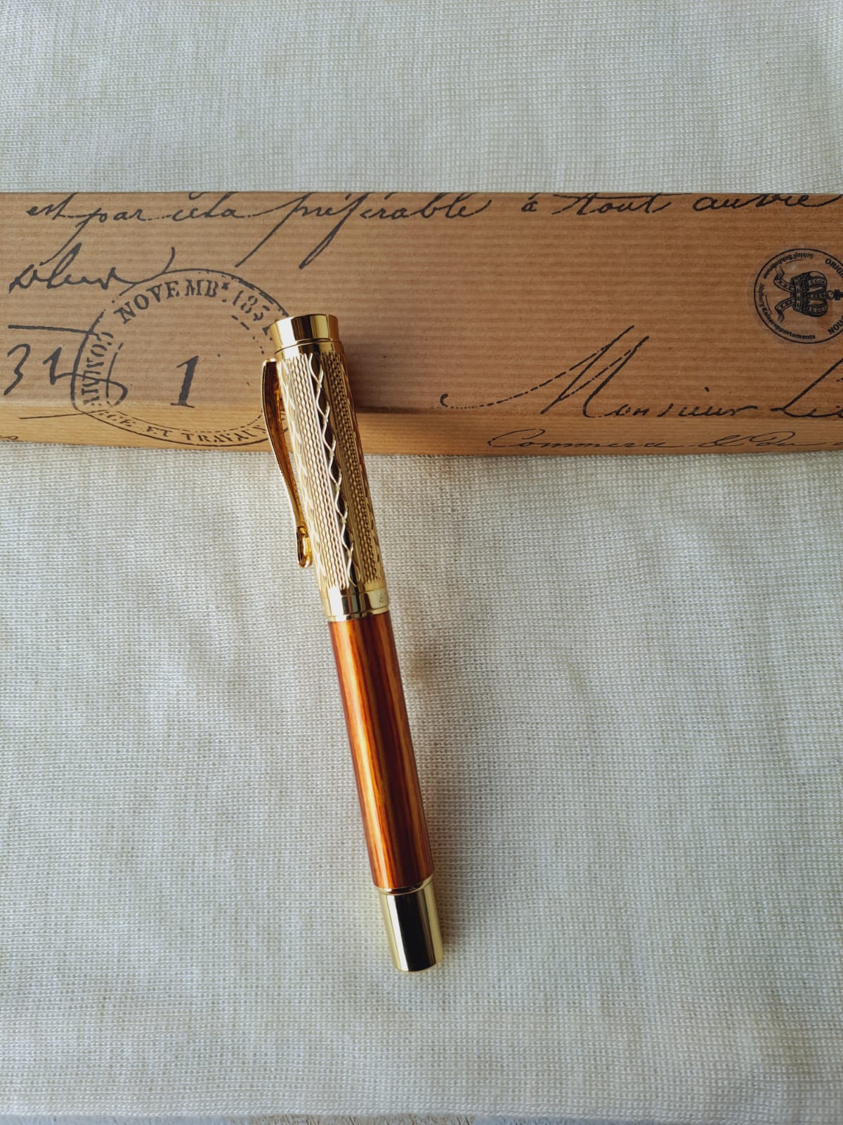 Elegant gold and amber designer pen on vintage envelope