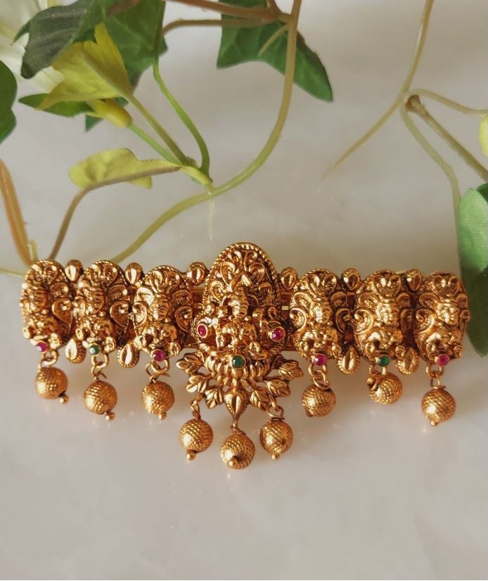 Elegant gold-plated designer hair accessory with detailed floral motifs and dangling ornaments from Mugdha Jewellery Store