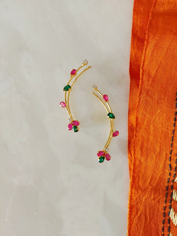 Vibrant Gemstone Drop Earrings - Multicolored beaded gold-tone earrings with ruby, emerald, and diamond-shaped accents, displayed on an orange fabric backdrop.