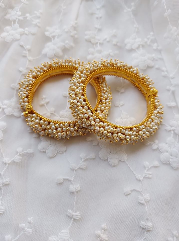 Elegant pearl-embellished gold bangles from Mugdha Jewellery Store