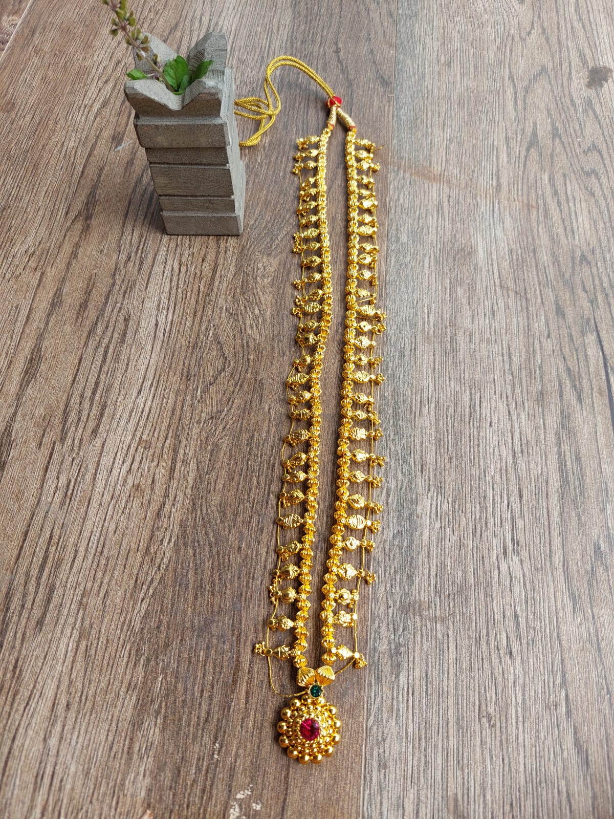 Small Dholki Bead Plain Kolhapuri Saaj Long (30 Inch) - Vibrant yellow beaded necklace with traditional pendant on a wooden floor.