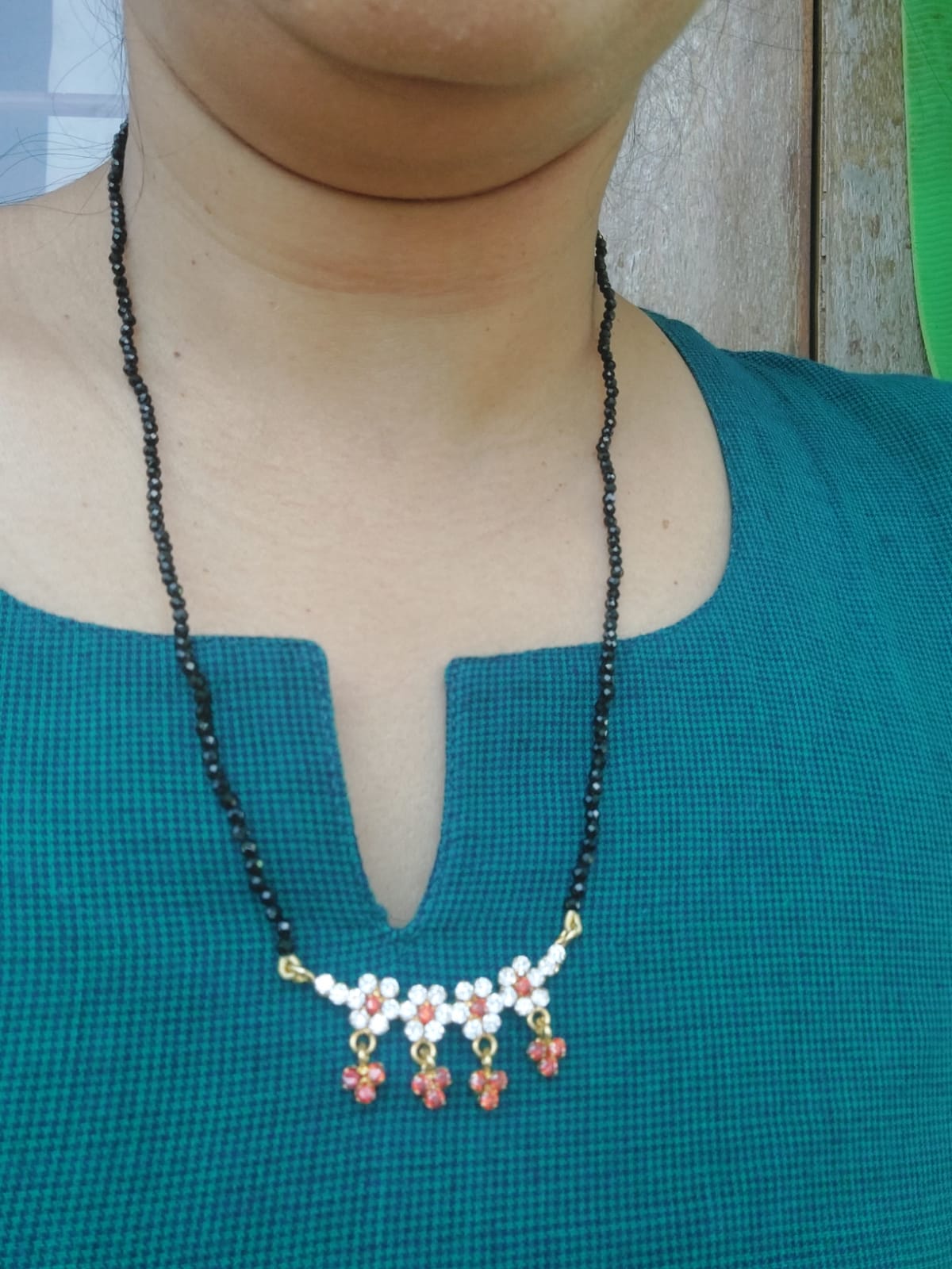 Orange Stone Flower Crystal Mangalsutra necklace on woman's blue top