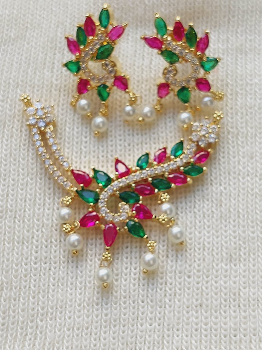 Multicolored designer pendant mangalsutra with vibrant gemstones, elegant pearl accents, and intricate golden metalwork displayed on white fabric background.