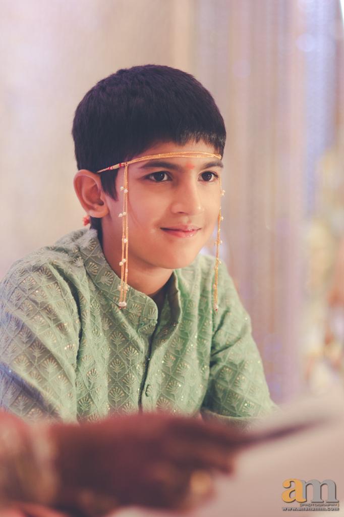 Smiling young boy wearing green sweater and headband