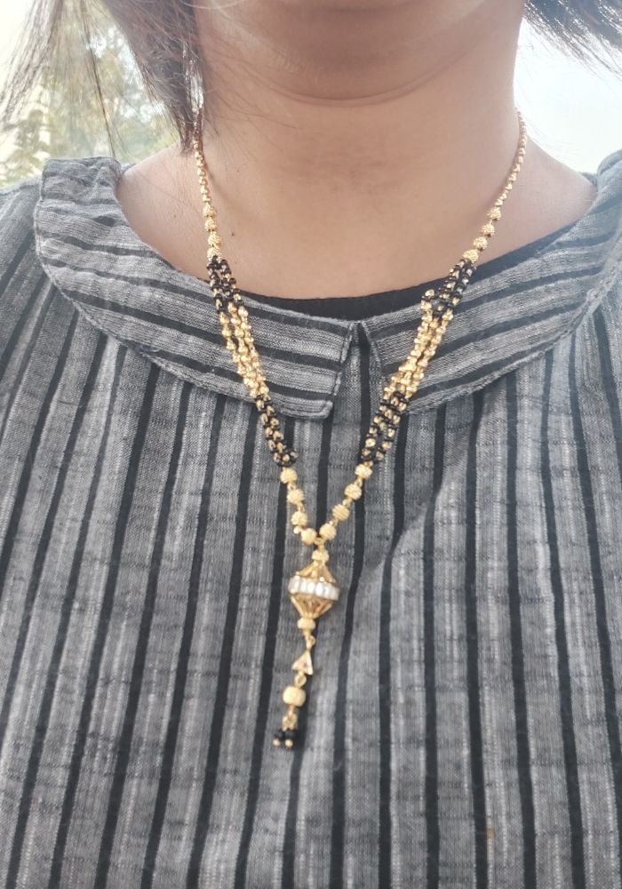 Designer Short Round Stone Mangalsutra with golden beads and pendant on a woman's clothing