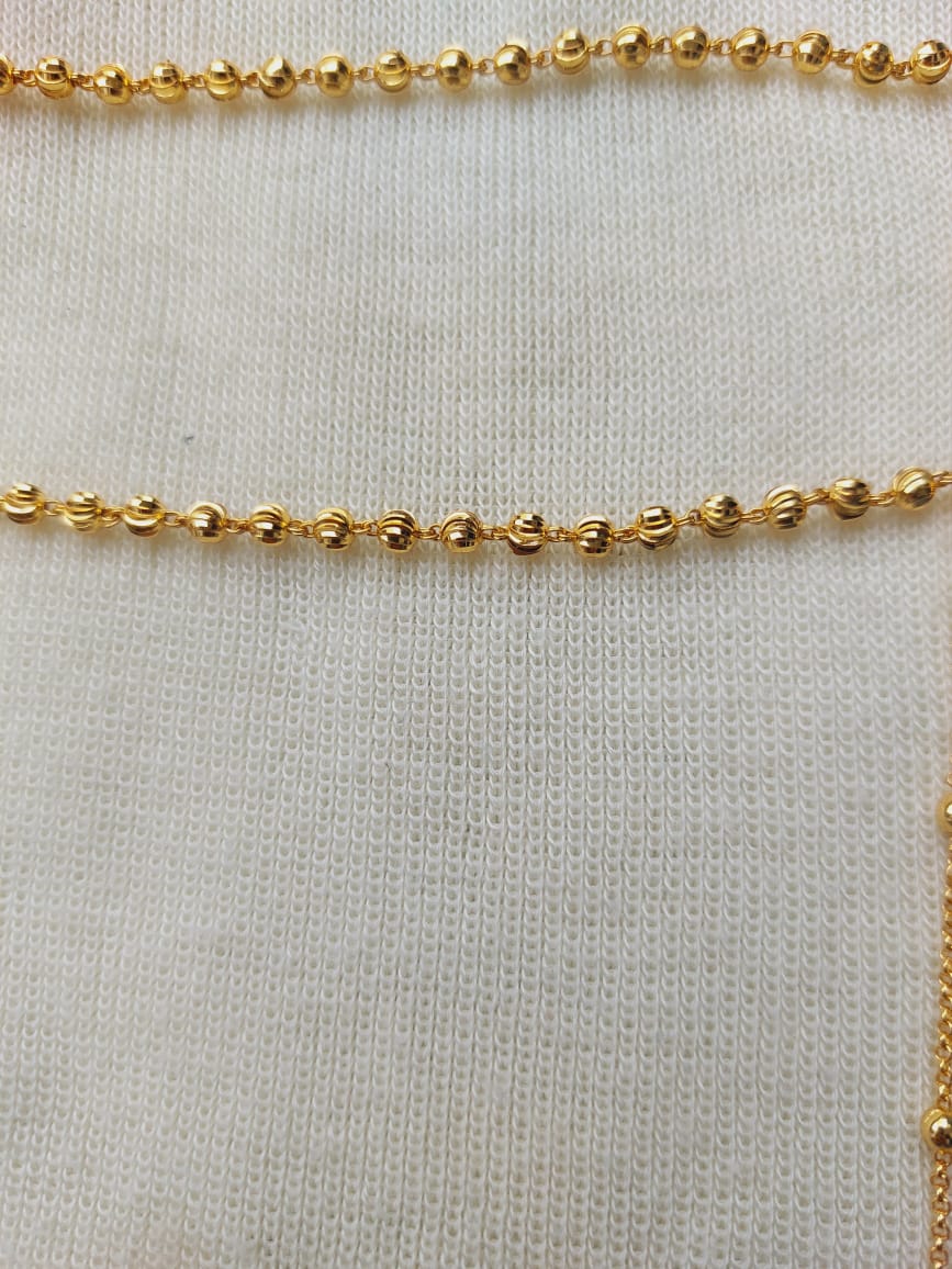 Delicate and Elegant Golden Mundavali
A beautiful gold-toned chain with intricate beaded details, displayed on a plain white knitted fabric.