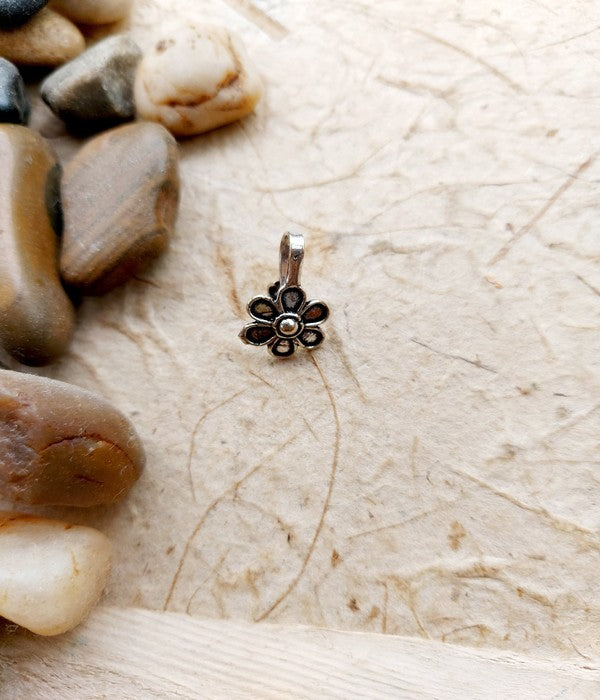 Elegant Oxidised Flower Nose Pin on Pebble Background