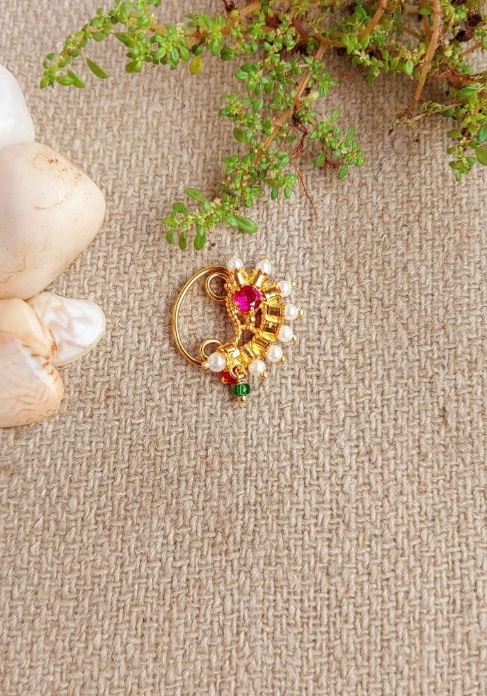 Elegant South Indian Nath - Colorful Gold Nose Ring with Sparkling Gems on Textured Carpet Background