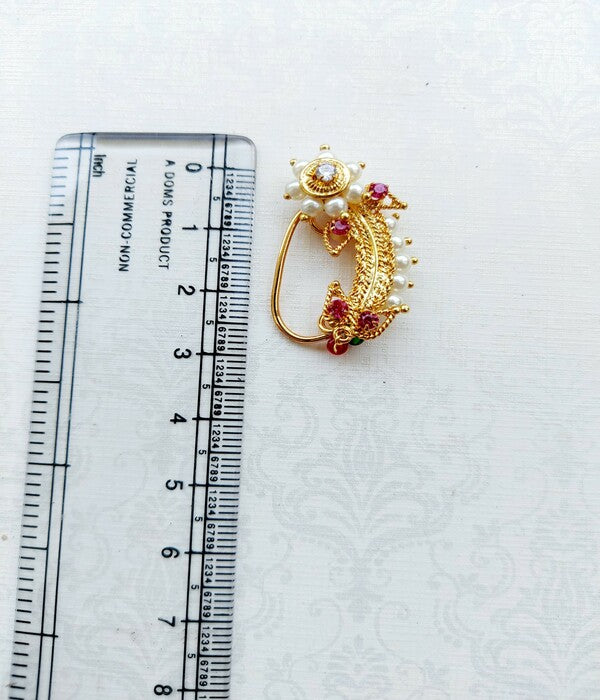 Elegant gold-tone koi fish pendant with red and white gemstones, displayed on a ruler for scale.