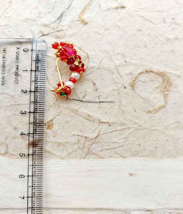 Traditional red and orange nath adornment on marble surface