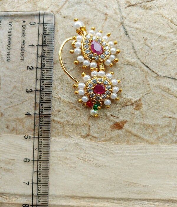 Exquisite gold-toned Karwari Nath featuring vibrant red gemstones and delicate faux pearls, meticulously crafted by Mugdha Jewellery Store.