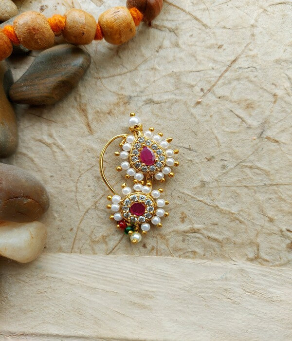 Elegant gold and pearl Karwari Nath jewelry showcased on a textured light background.