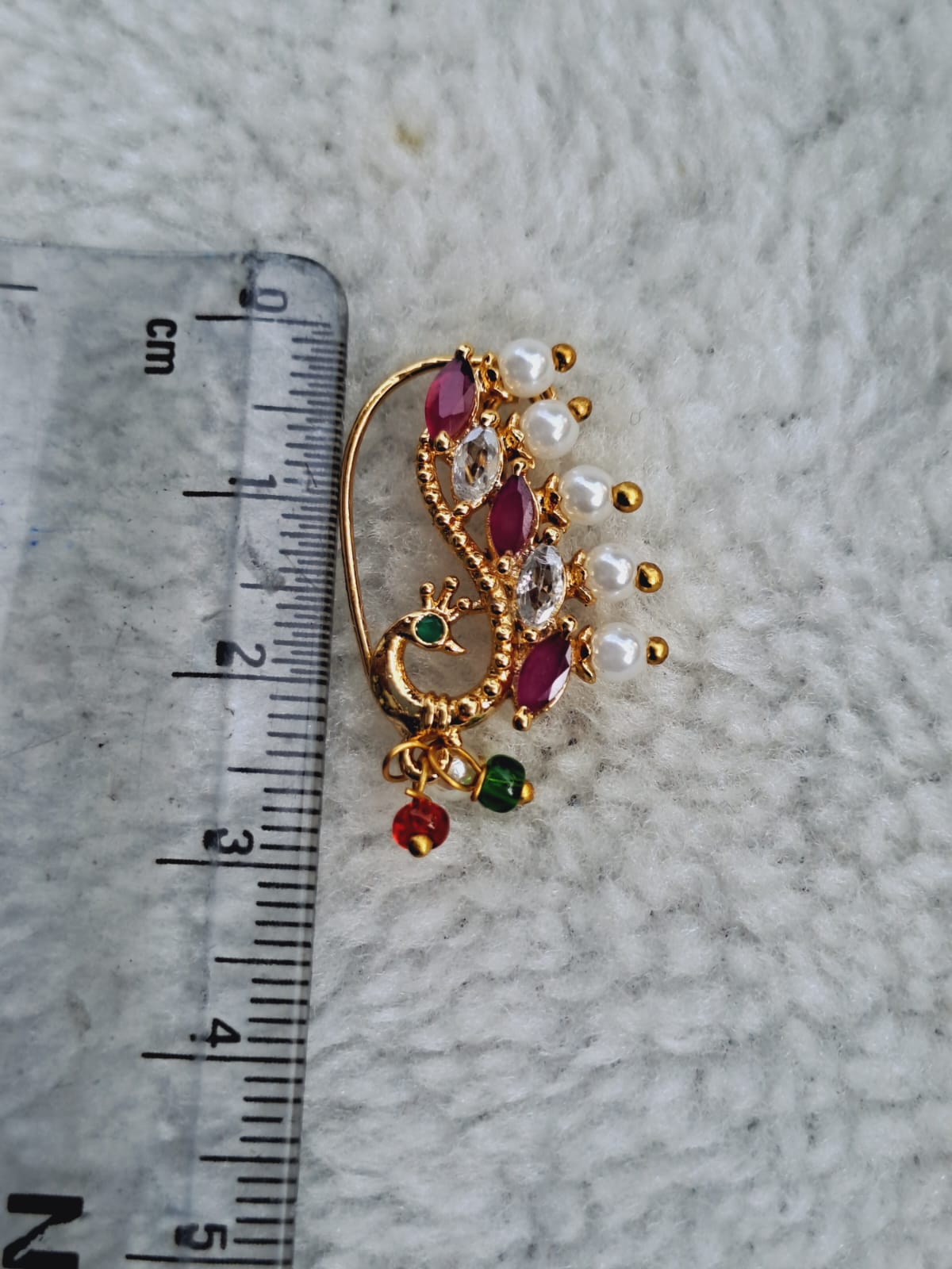 Elegant gold-toned nose ring with vibrant red gemstones and pearly accents