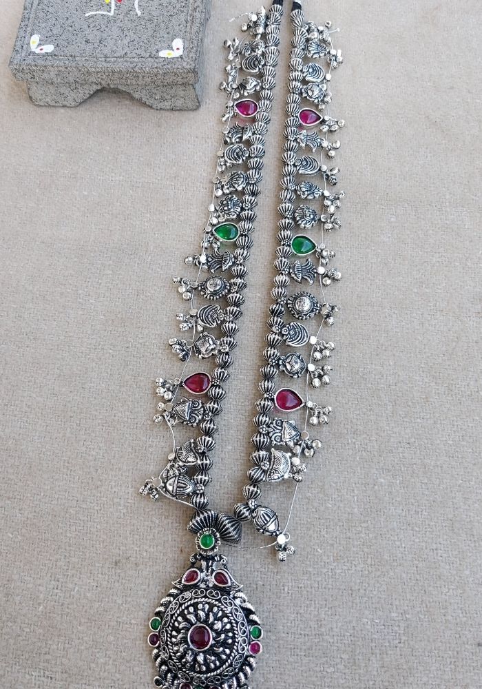 Intricate oxidized silver long necklace with colorful gemstones, pendant and floral motifs from Mugdha Jewellery Store.