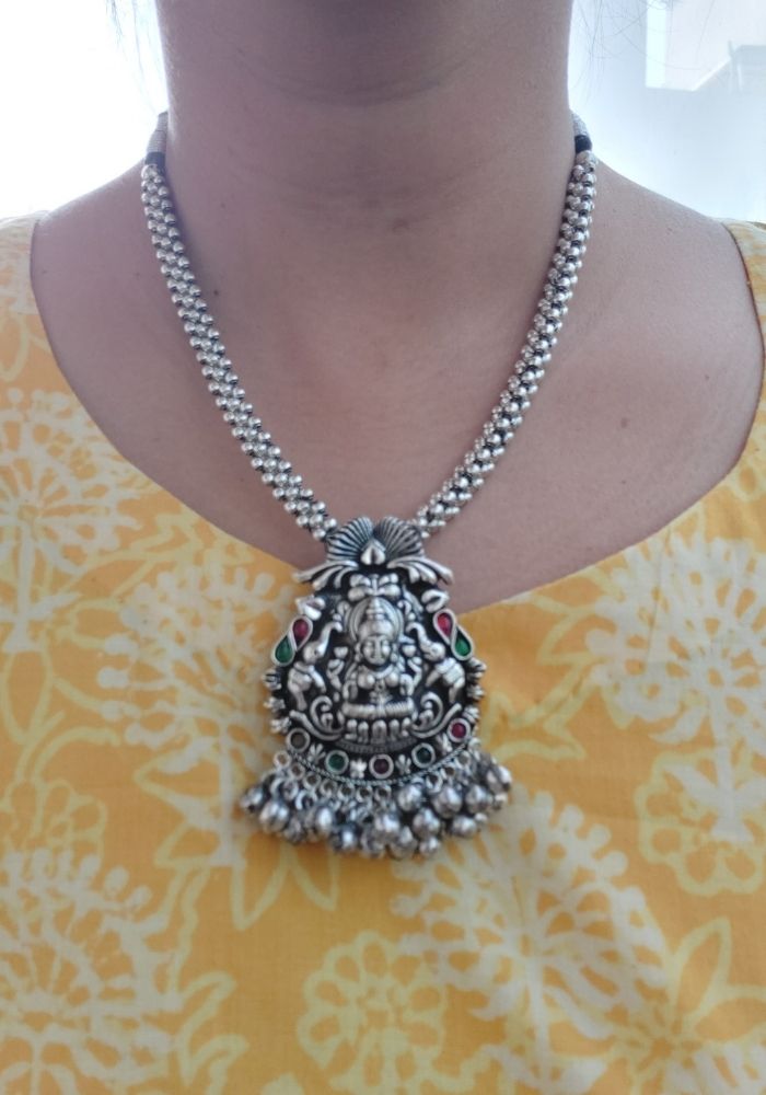 Exquisite oxidized silver Temple Thushi necklace with intricate Ganesha pendant, adorned with delicate beaded chain, showcased in the image from the Mugdha Jewellery Store.