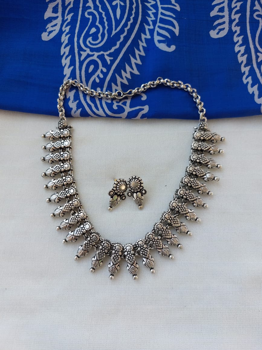 Oxidized Silver Necklace Set from Mugdha Jewellery Store featuring an intricate design with beaded charms and a matching ring.