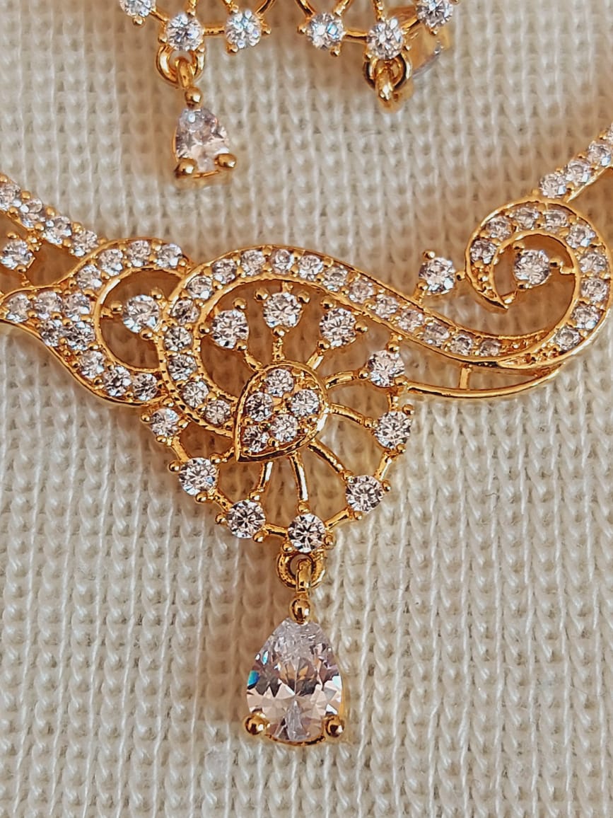 Stunning gold-tone pendant necklace featuring an intricate floral design encrusted with sparkling American diamonds from the Mugdha Jewellery Store collection.