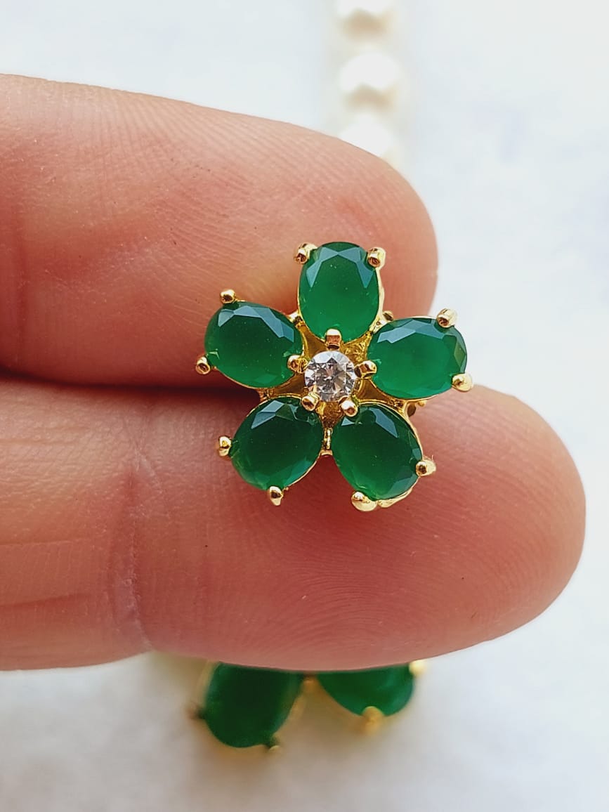 Green Flower Pearl Set - Elegant gold-tone ring with emerald-green stones and a central diamond accent, showcased on a human hand.