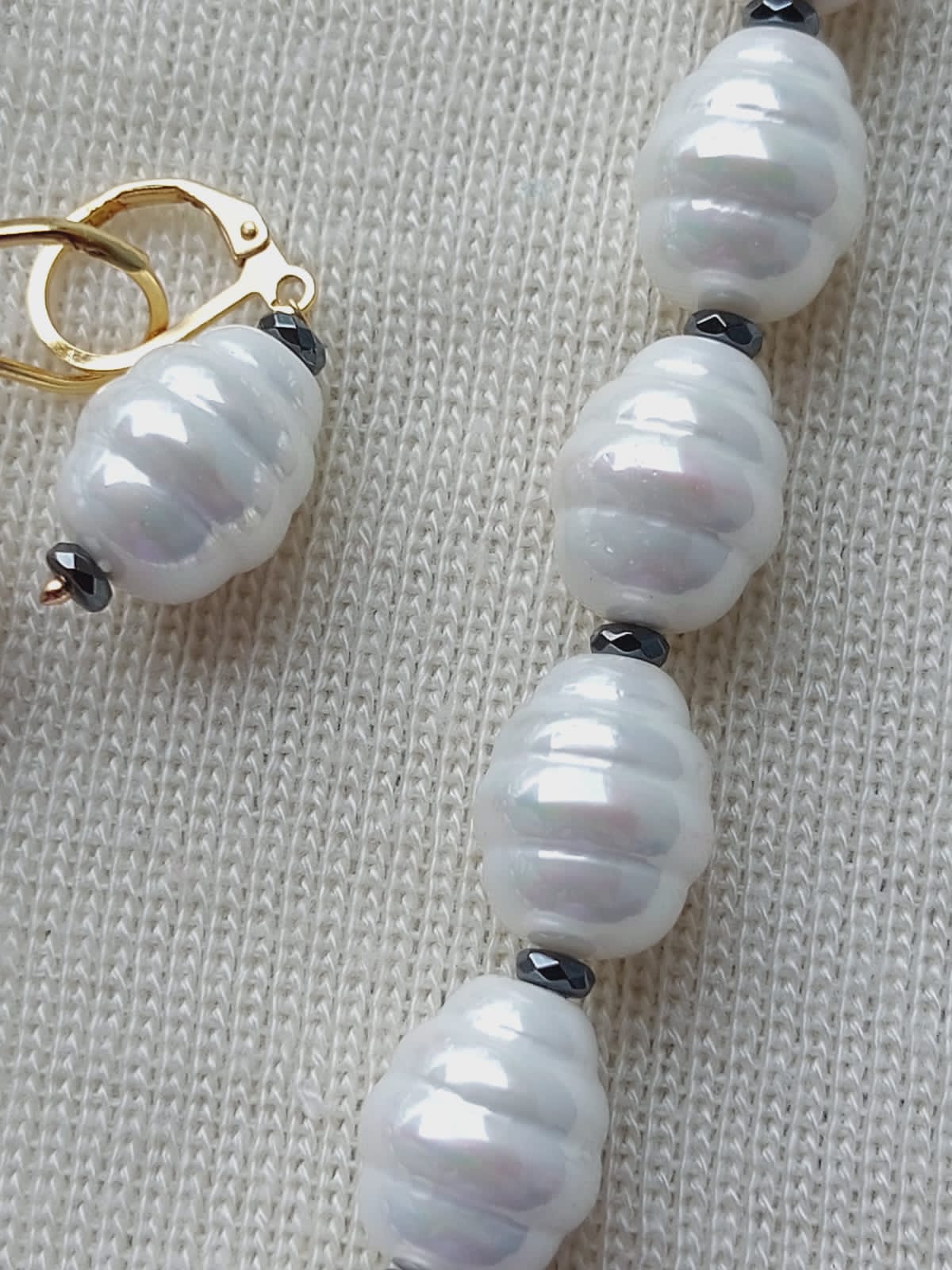 Elegant Pearl Jewelry Set: Lustrous white pearls arranged in a striking necklace, complemented by a matching pair of earrings, showcasing the high-quality craftsmanship of the Mugdha Jewellery Store.