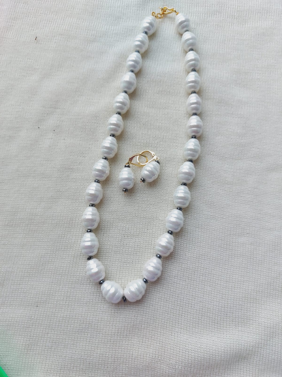 Elegant Pearl Necklace - White freshwater pearls arranged in a stunning necklace, showcased against a neutral background.