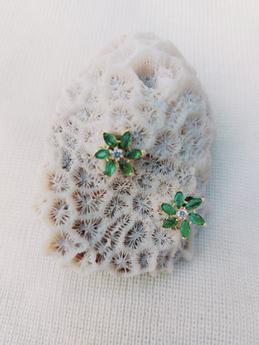 Exquisite Green Stone Star Flower Stud Earrings from Mugdha Jewellery Store, adorned with delicate floral motifs against a captivating coral reef backdrop.